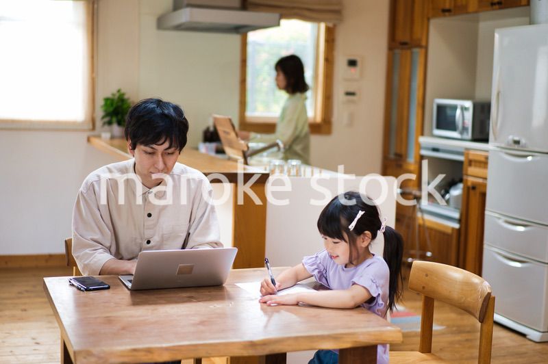 テレワークをする大人と家にいる子ども