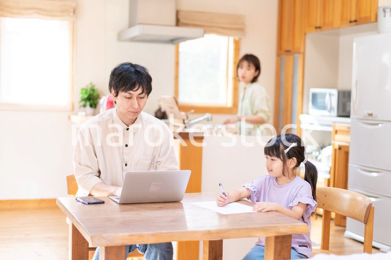テレワークをする夫婦と子供