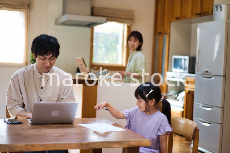 テレワークをする大人と家にいる子ども