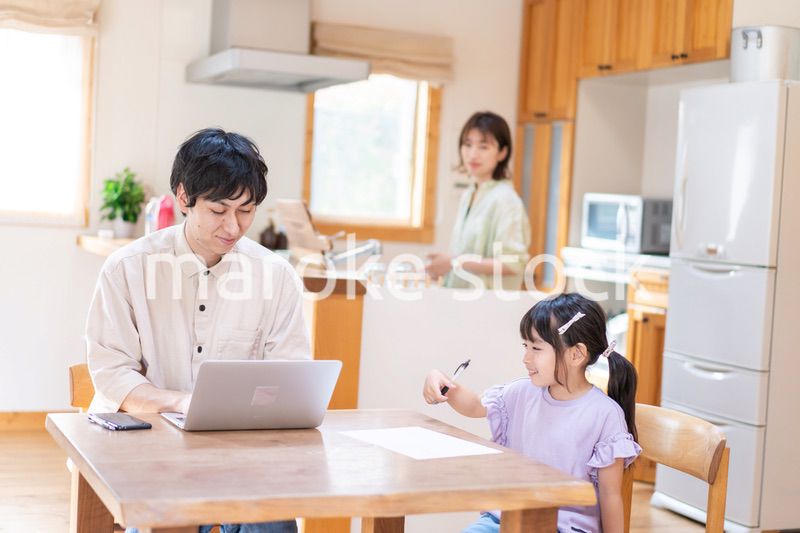 テレワークをする夫婦と子供