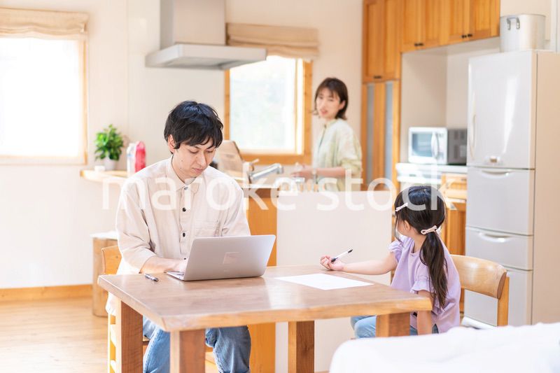 テレワークをする夫婦と子供
