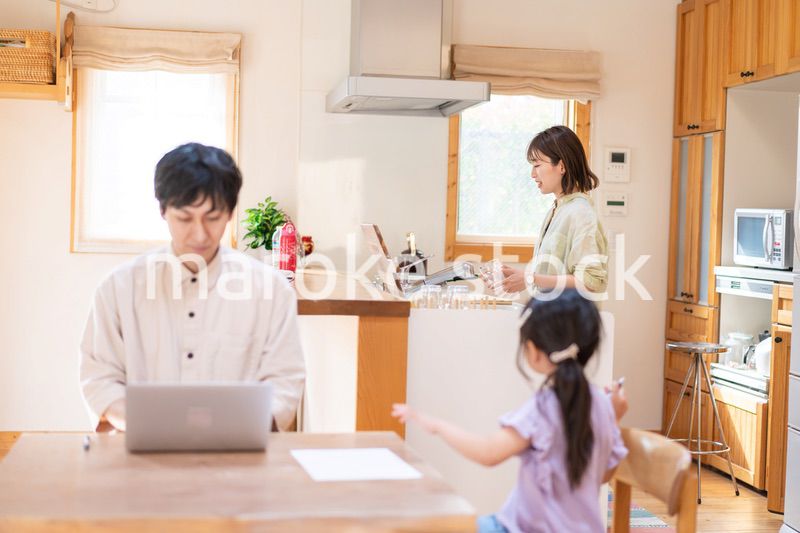 テレワークをする夫婦と子供