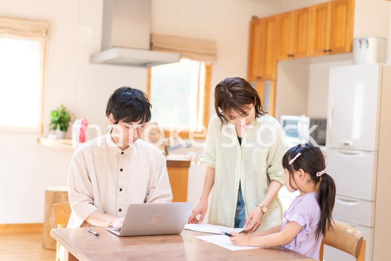 テレワークをする夫婦と子供