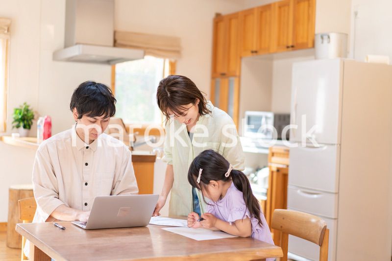 テレワークをする夫婦と子供
