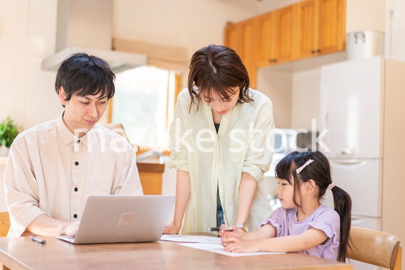 テレワークをする夫婦と子供