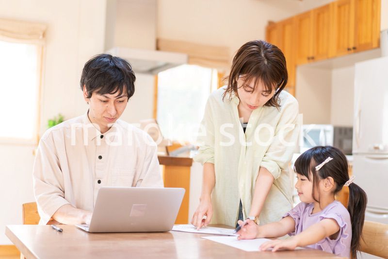 テレワークをする夫婦と子供