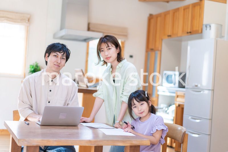 テレワークをする夫婦と子供