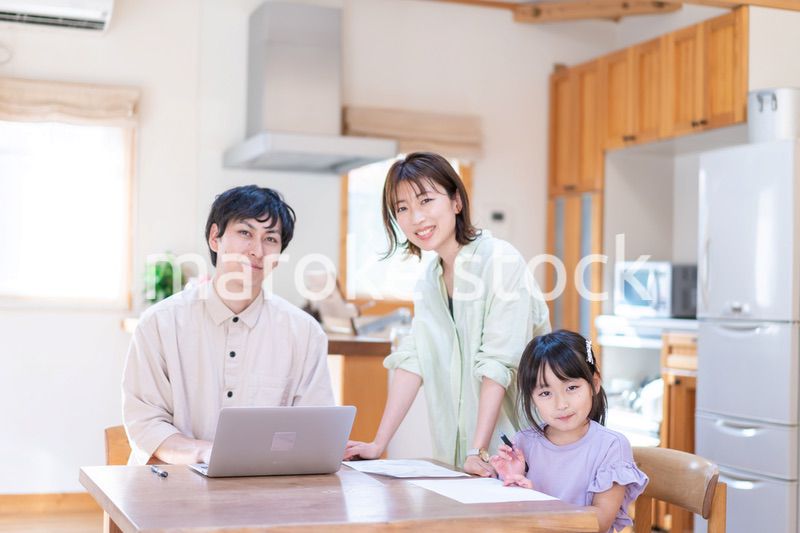 テレワークをする夫婦と子供