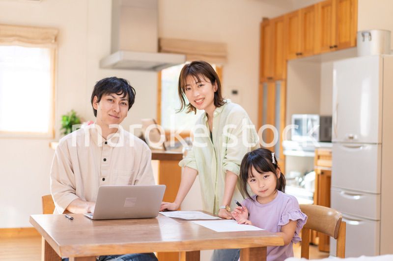 テレワークをする夫婦と子供