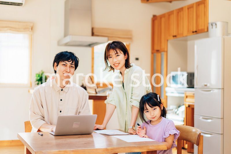 テレワークをする夫婦と子供