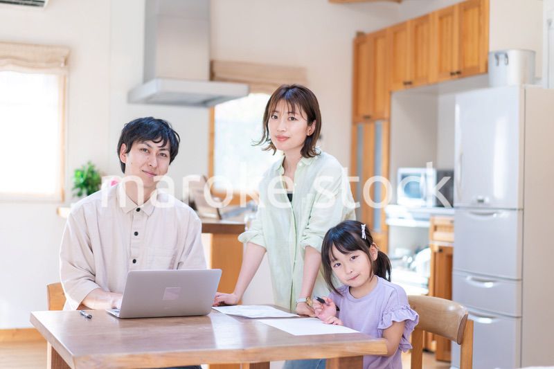 テレワークをする夫婦と子供