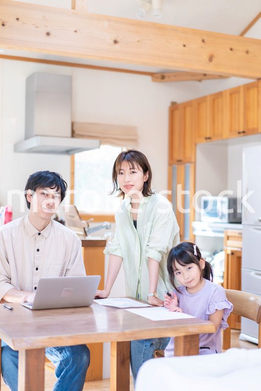 テレワークをする夫婦と子供