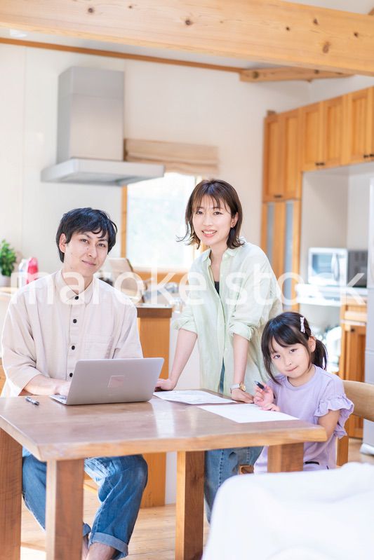 テレワークをする夫婦と子供