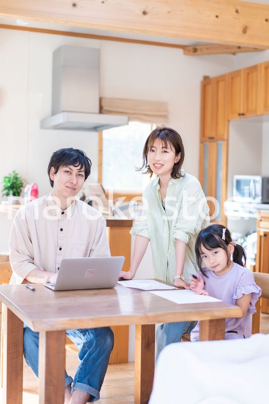 テレワークをする夫婦と子供
