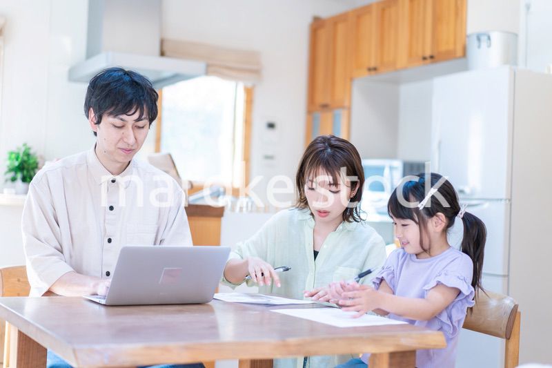 テレワークをする夫婦と子供