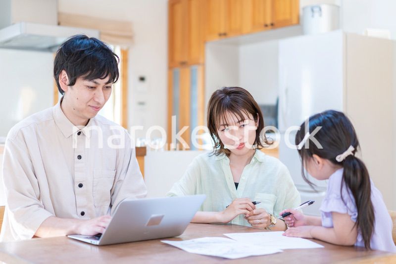 テレワークをする夫婦と子供