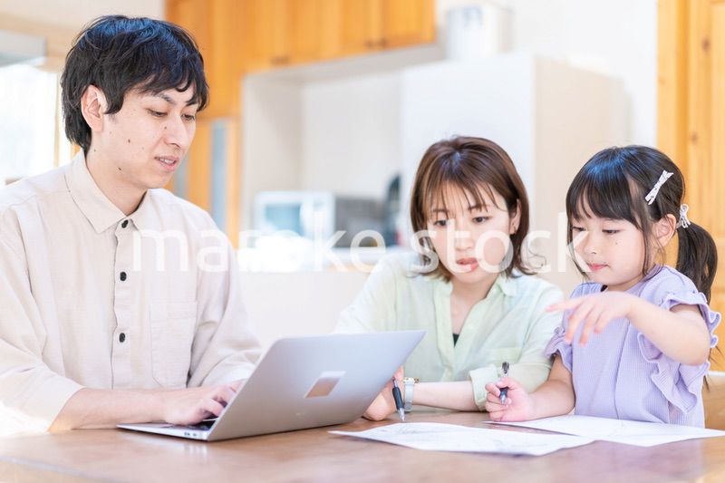 テレワークをする夫婦と子供