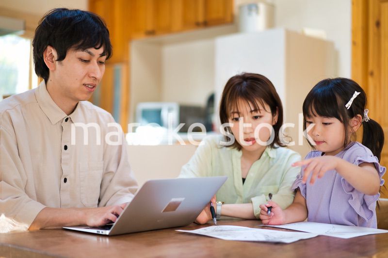 テレワークをする大人と家にいる子ども