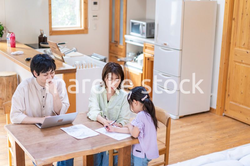 テレワークをする夫婦と子供