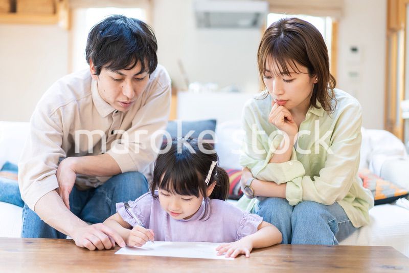 家でお勉強をする女の子と両親