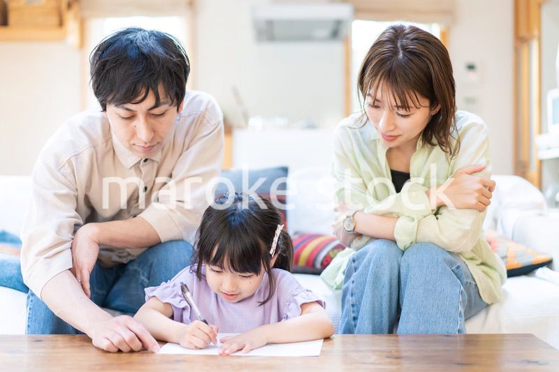 家でお勉強をする女の子と両親
