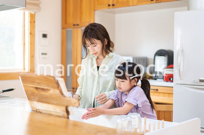 お母さんと一緒に料理をする小さな女の子