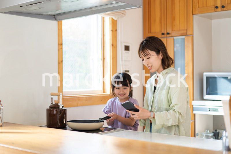 お母さんと一緒に料理をする小さな女の子