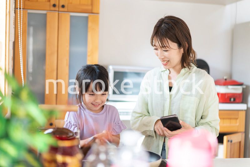お母さんと一緒に料理をする小さな女の子