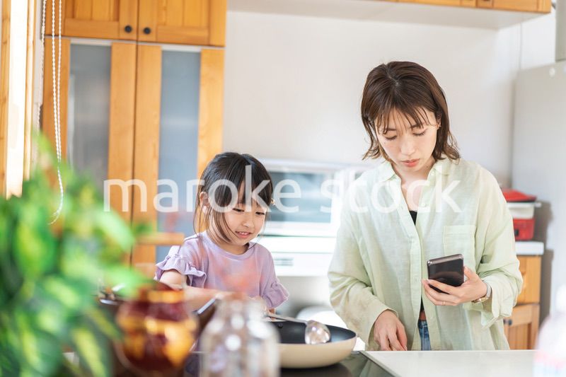 お母さんと一緒に料理をする小さな女の子