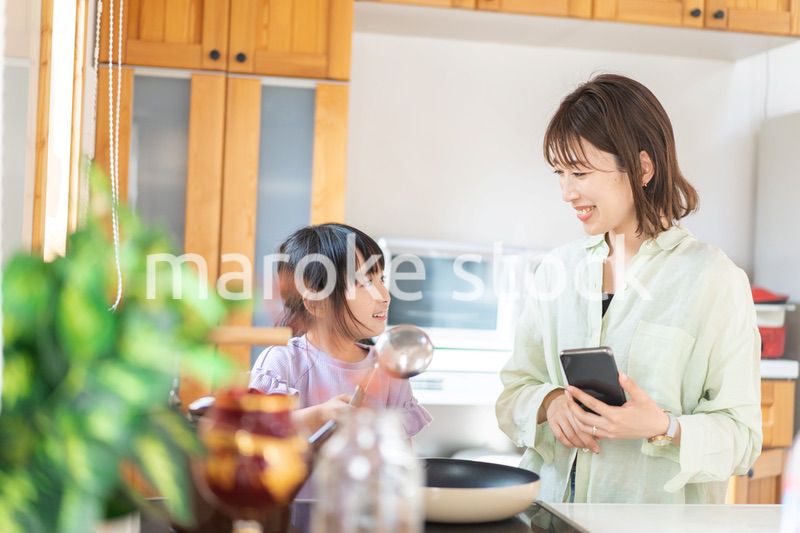 お母さんと一緒に料理をする小さな女の子