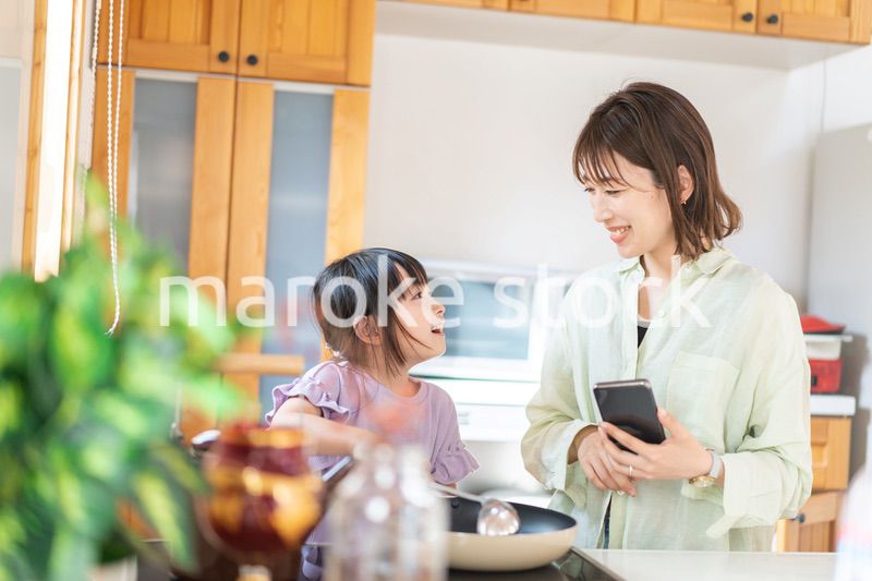 お母さんと一緒に料理をする小さな女の子