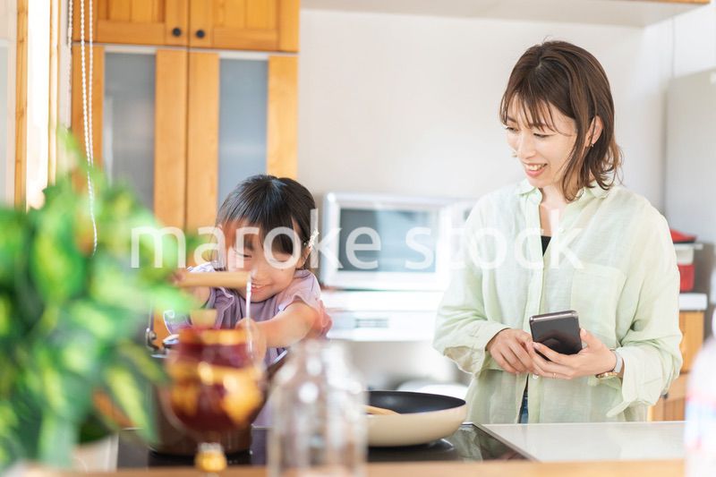 お母さんと一緒に料理をする小さな女の子