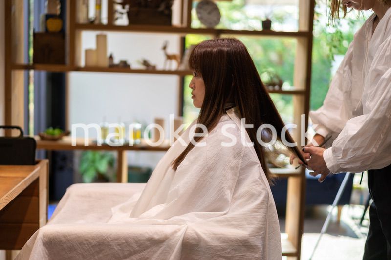 女性のヘアカットをする美容師