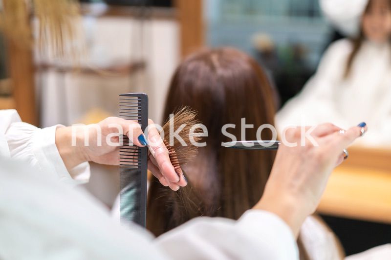 女性のヘアカットをする美容師