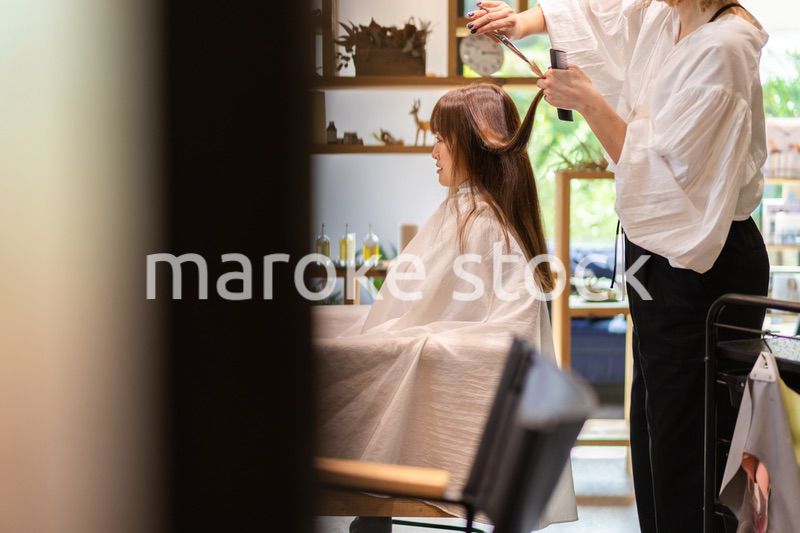 女性のヘアカットをする美容師