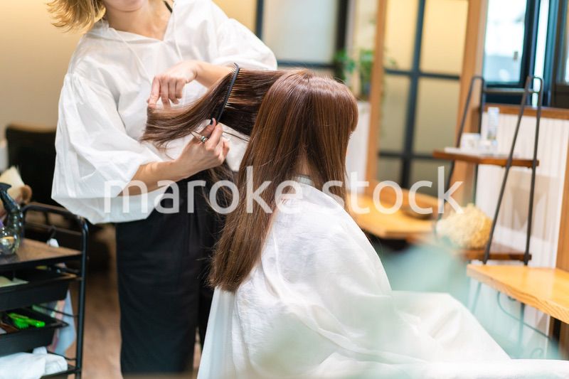 美容室で髪をカットする女性