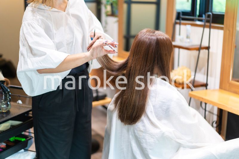 美容室で髪をカットする女性