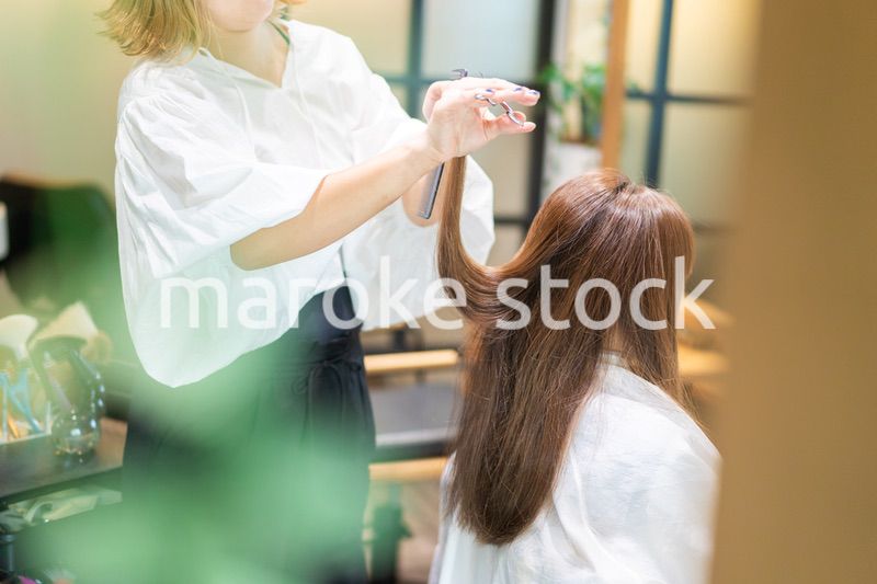 女性のヘアカットをする美容師