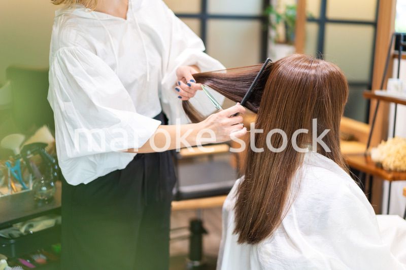 女性のヘアカットをする美容師