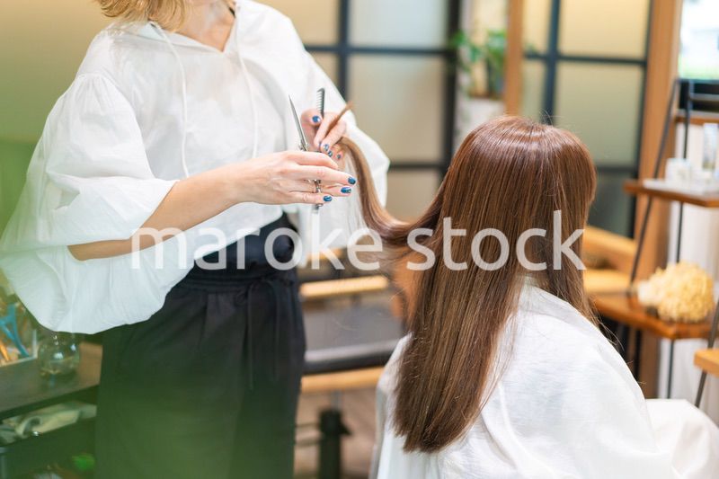 女性のヘアカットをする美容師