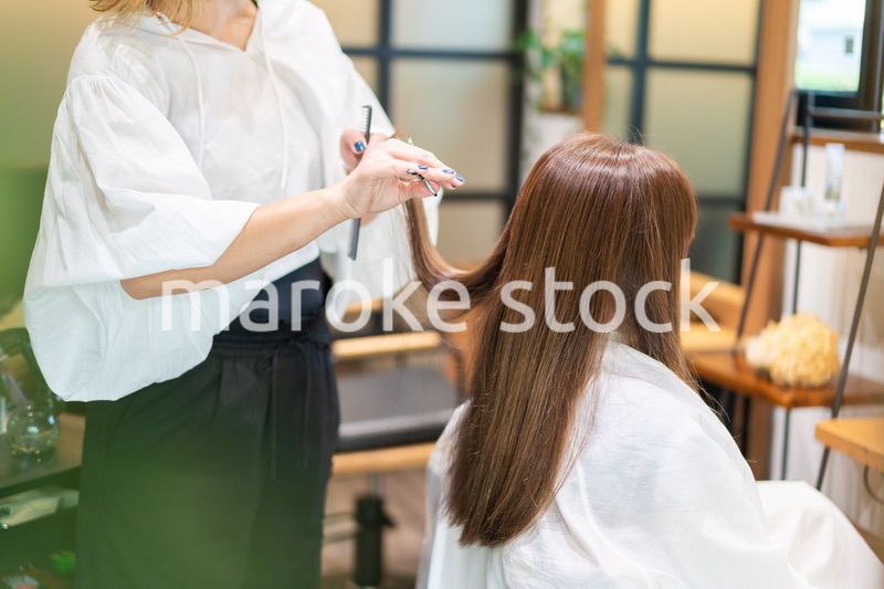 女性のヘアカットをする美容師