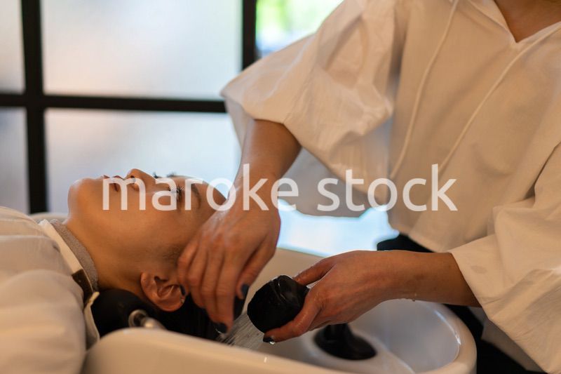 お客様にシャンプーをする美容師