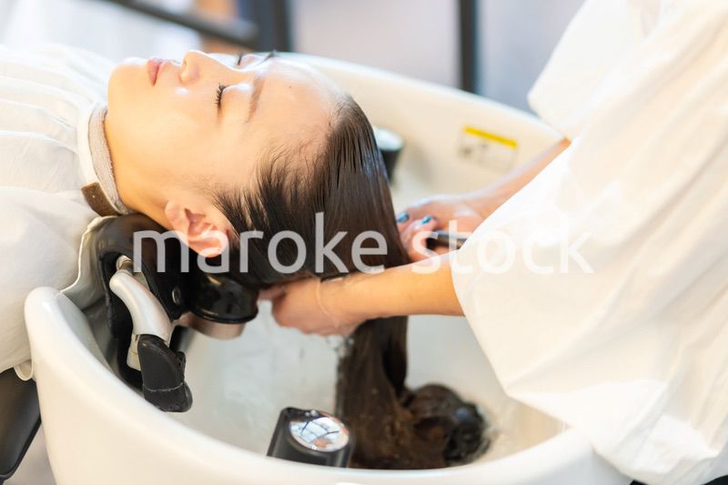 お客様にシャンプーをする美容師