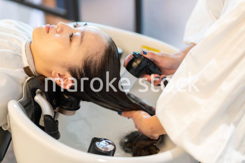 お客様にシャンプーをする美容師