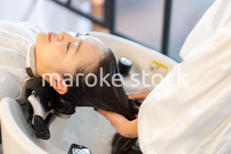 お客様にシャンプーをする美容師