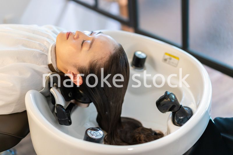 お客様にシャンプーをする美容師