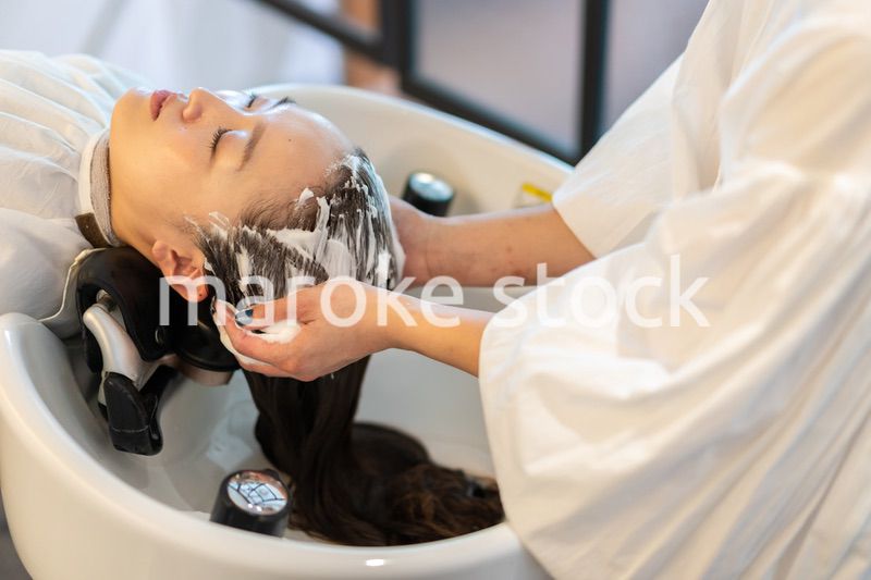 お客様にシャンプーをする美容師