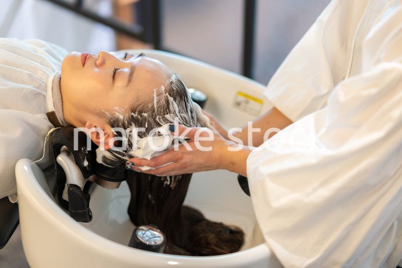 お客様にシャンプーをする美容師