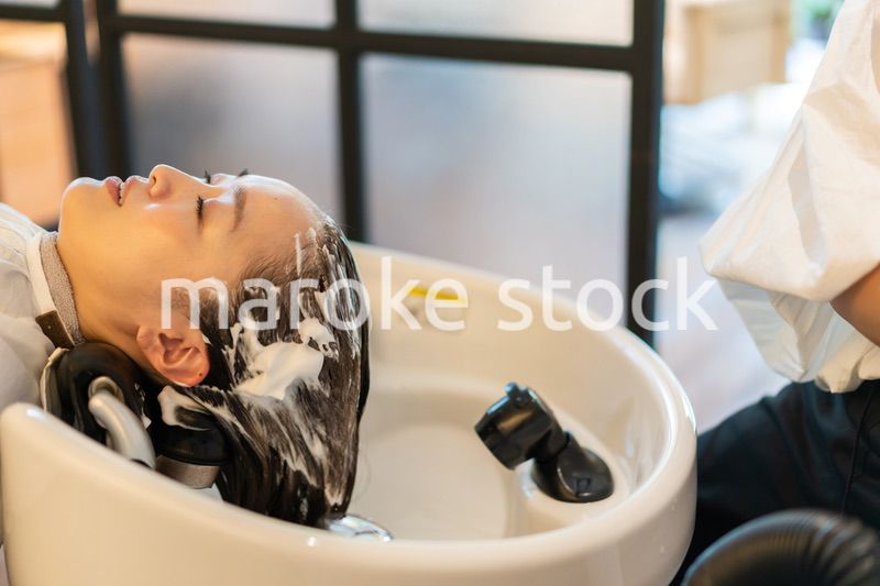 お客様にシャンプーをする美容師