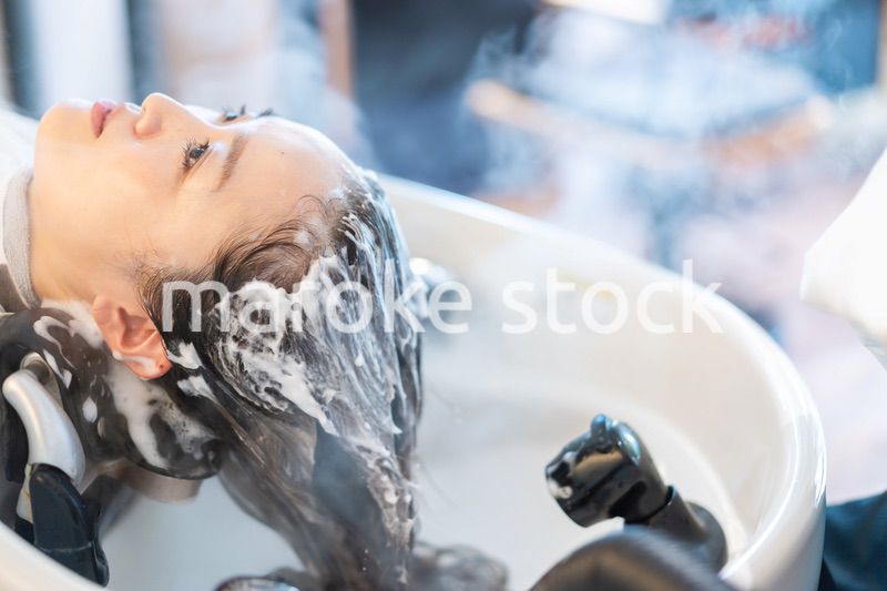 ヘアサロンでスチームトリートメントを受ける女性